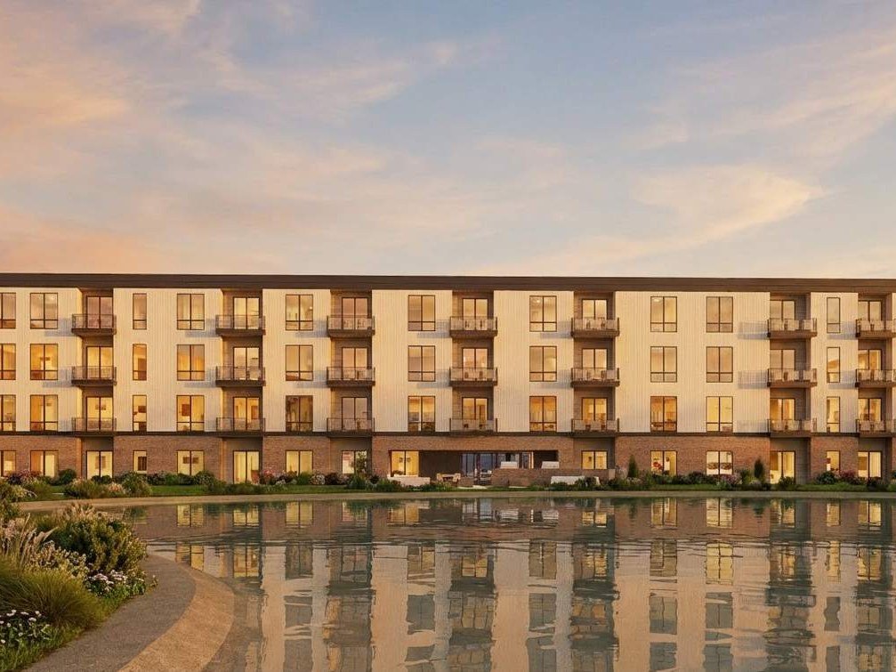 Rendering of an Urban Prairie apartment building beside the pond at sunset
